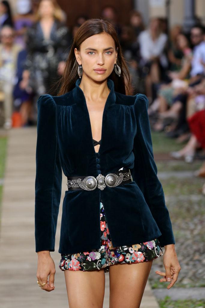 Modelul Irina Shayk, într-un sacou negru și o fustă scurtă, înflorată
