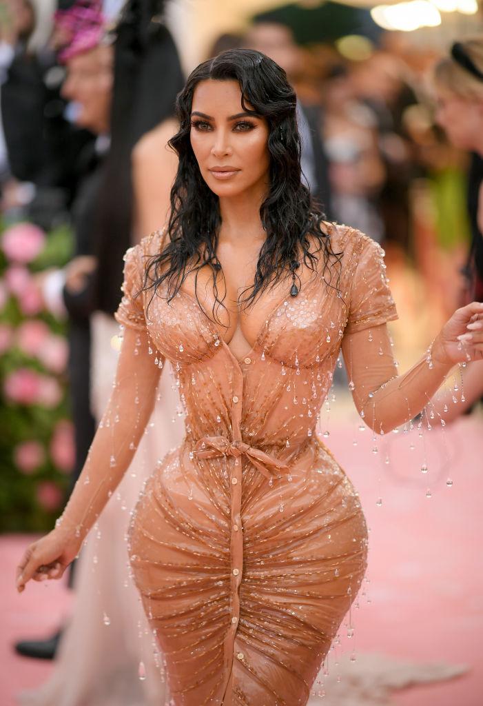 Kim Kardashian imbracata intr-o rochie crem, cu decolteu amplu