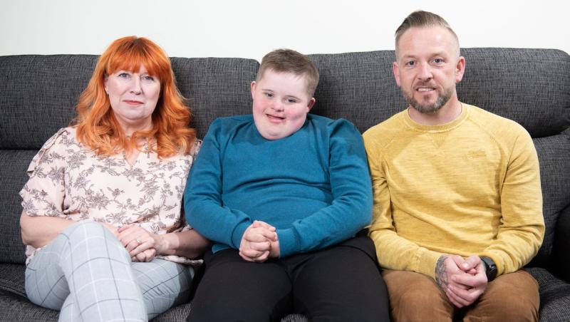 Claire Burke și David  stand pe o canapea impreuna cu fiul lor