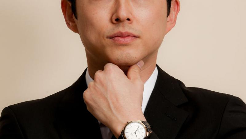 Steven Yeun, îmbrăcat lîn costum negru