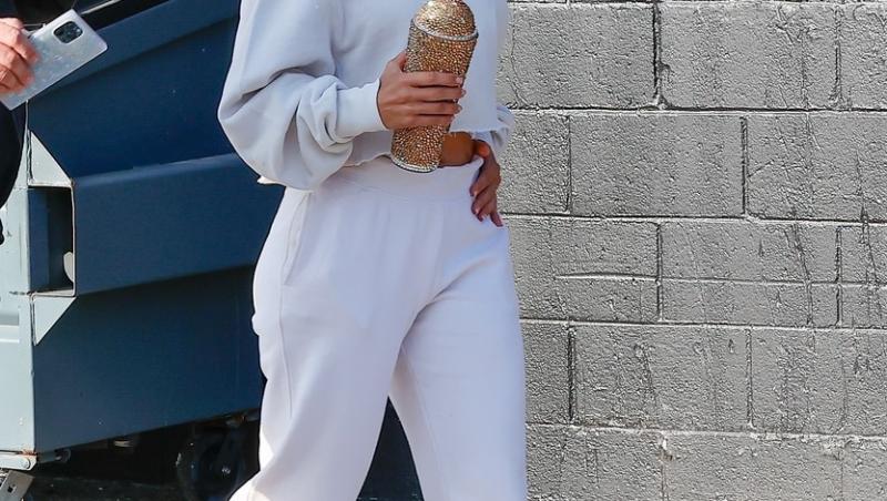 Jennifer Lopez într-un compleu alb, pe stradă și un termos în mână