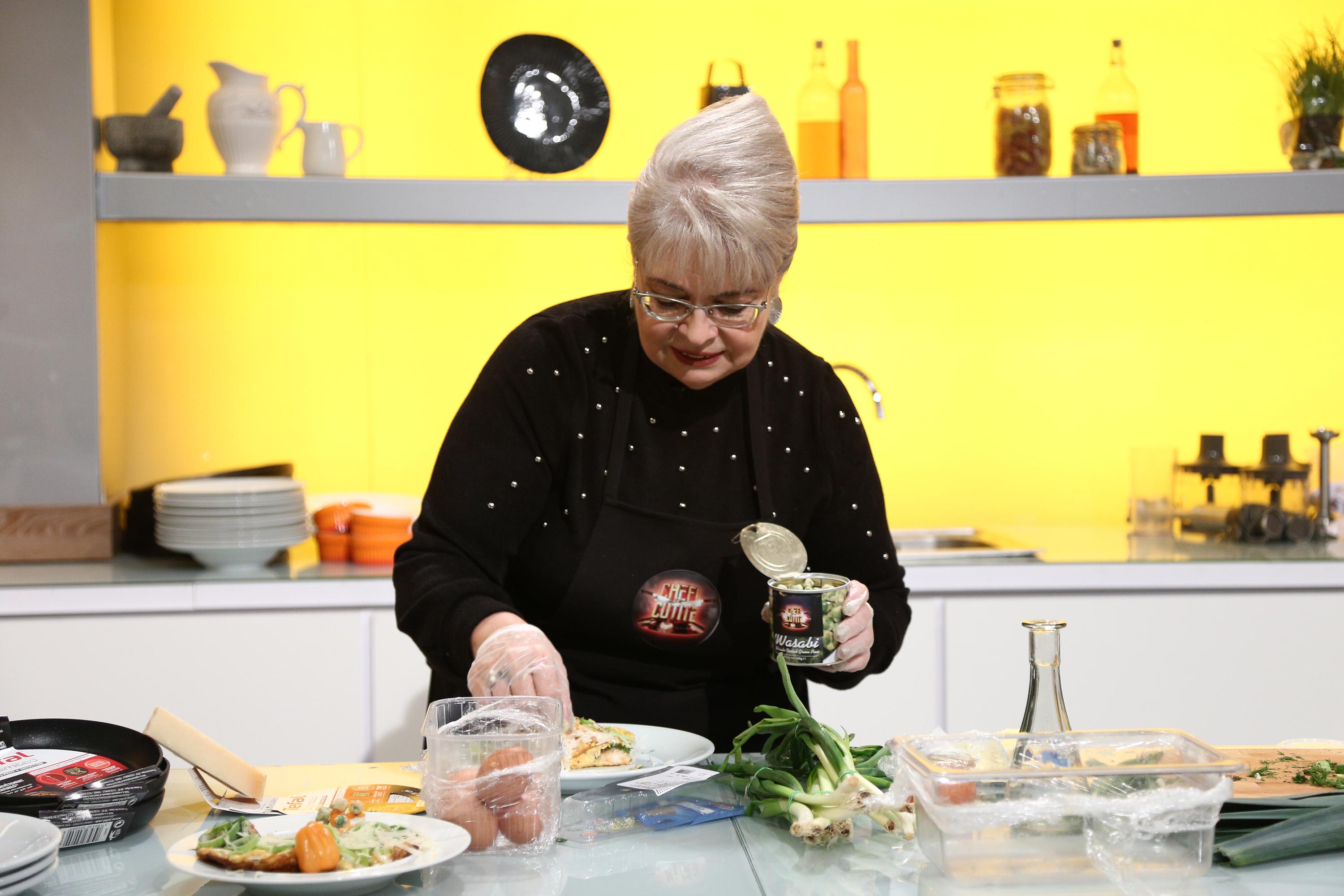 irina margareta nistor, chefi la cutite, imbracata in negru, fundal galben