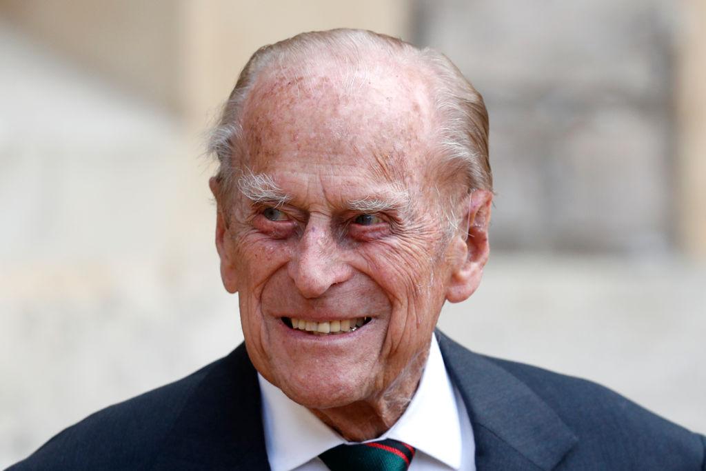 Prințul Philip zâmbind, purtâns sacou, cămașă și cravată