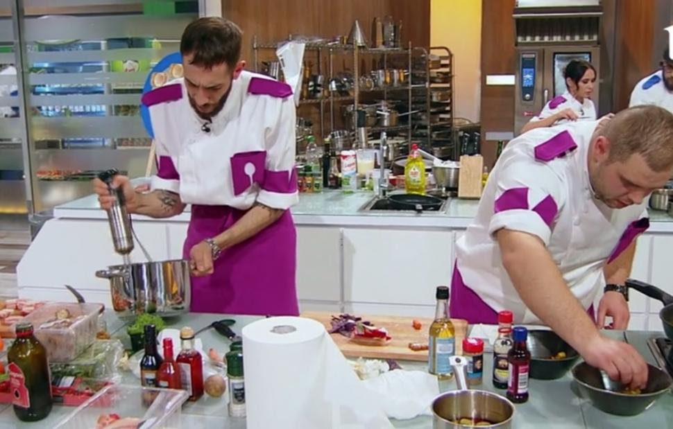 Luca Pintea este la masa de gătit, în stânga, alături de un alt concurent din echipa mov, aflat în dreapta lui