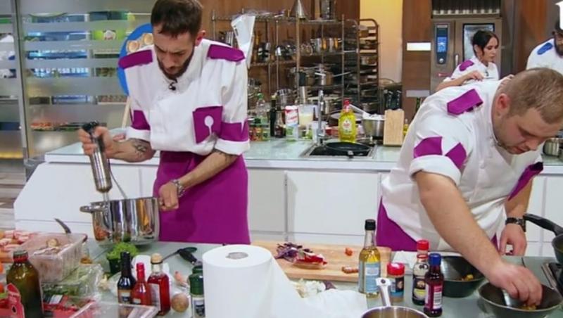 Luca Pintea este la masa de gătit, în stânga, alături de un alt concurent din echipa mov, aflat în dreapta lui