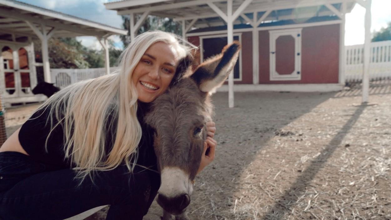 Sarah Lea, pozandu-se cu un magar, la o ferma