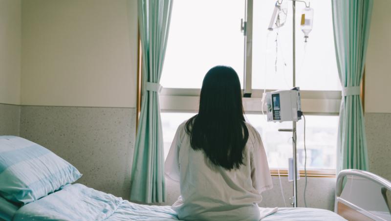 imagine cu o femeie stand pe un pat de spital, cu spatele