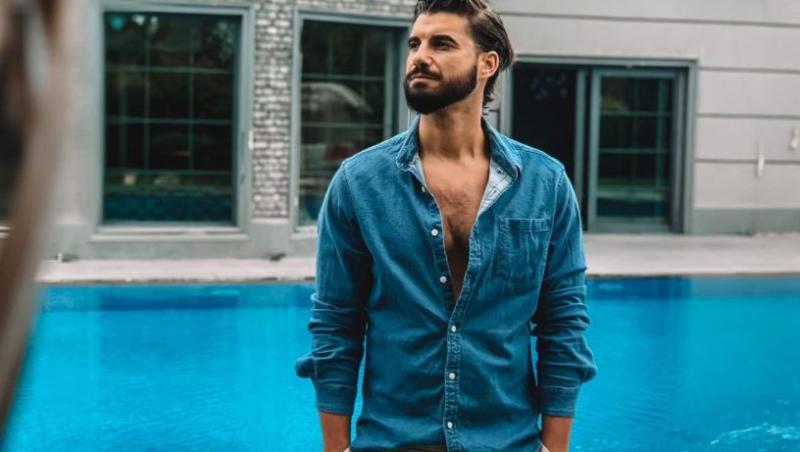 Andi Contantin, într-o cămașă albastră, stă lângă piscină