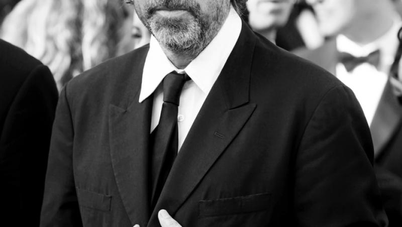 Tim Burton este îmbrăcat la costum, cu ochelari de vedere, fotografie alb negru