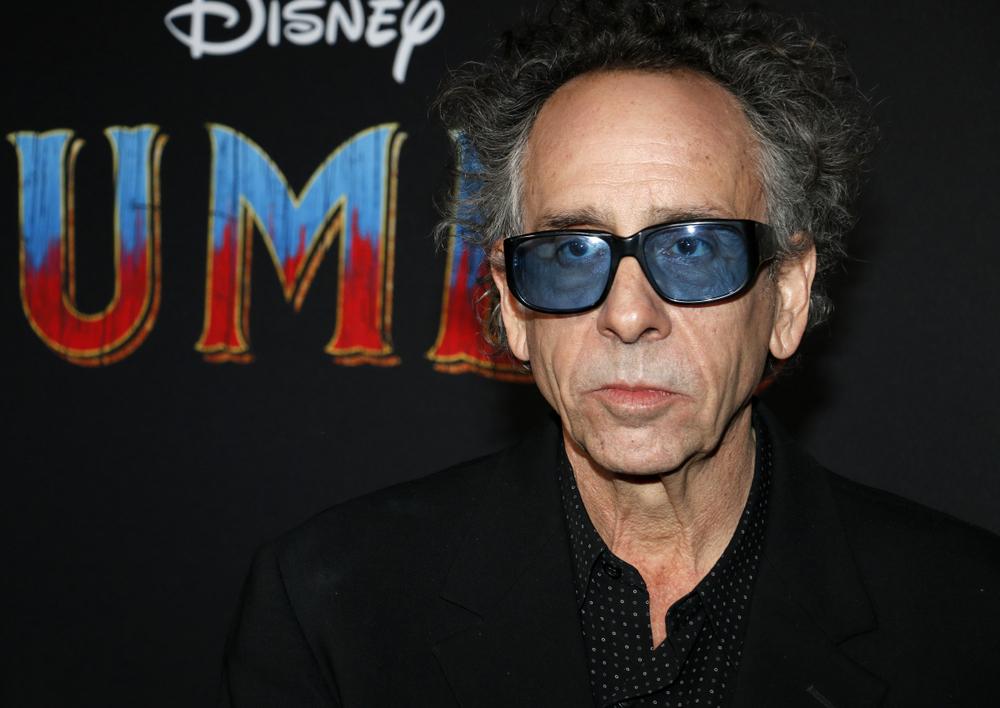 Tim Burton este îmbrăcat în negru, are ochelari la ochi