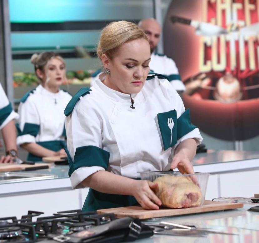 Victorina Mateveev în tunică albă și verde, gătește