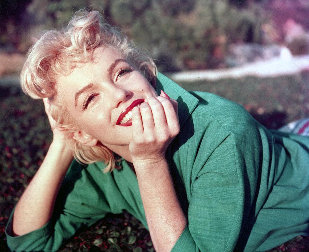 Marilyn Monroe, zâmbitoare, îmbrăcată într-o rochie verde