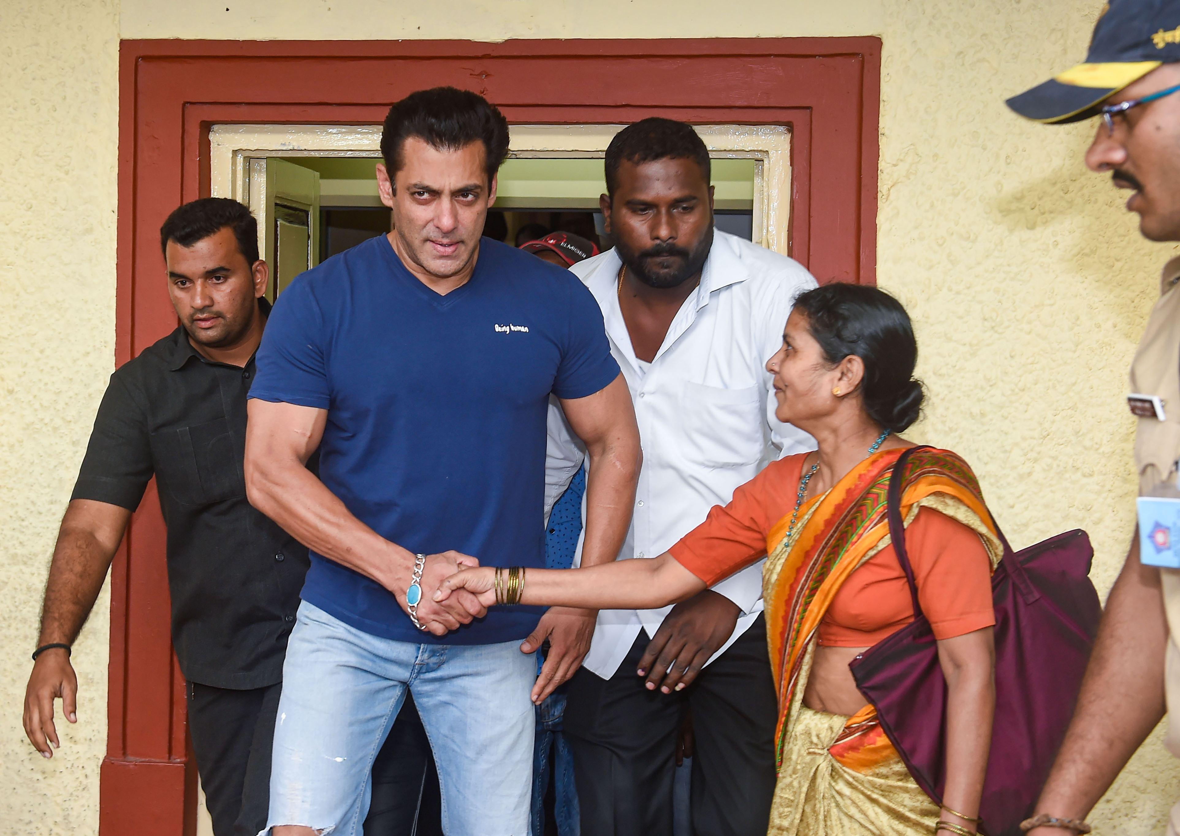 Salman Khan, îmbrăcat într-un tricou albastru, cu jeanși, salută apropiații.