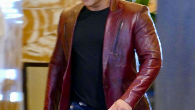 Salman Khan, surprins pe patourile de filmare. Este îmbrăcat într-un sacou de piele de culoare roșie.