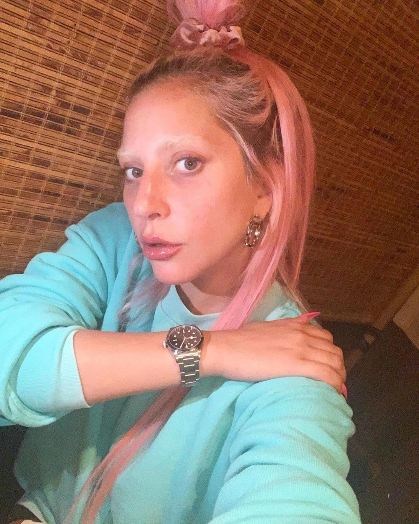 Lady Gaga are păr roz, îmbrăcată într-un hanorac albastru deschis