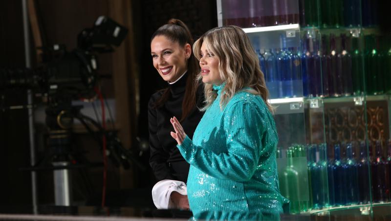 Gina PIstol în platoul emisiunii „Chefi la cuțite” sezonul 9, intr-o rochie albastra, imbratisand pe Irina Fodor