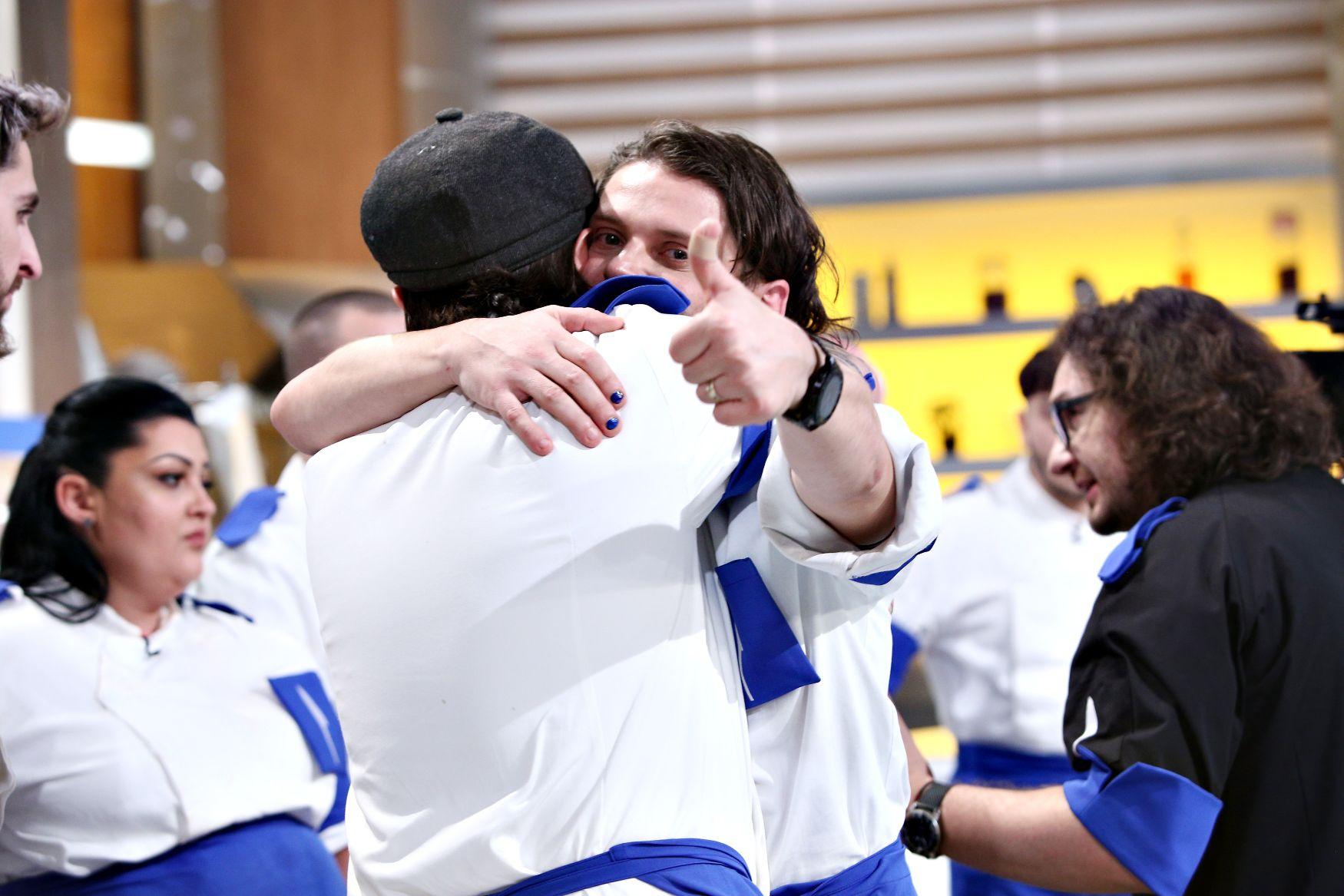 Concurenții echipei albastre îmbrățișându-se