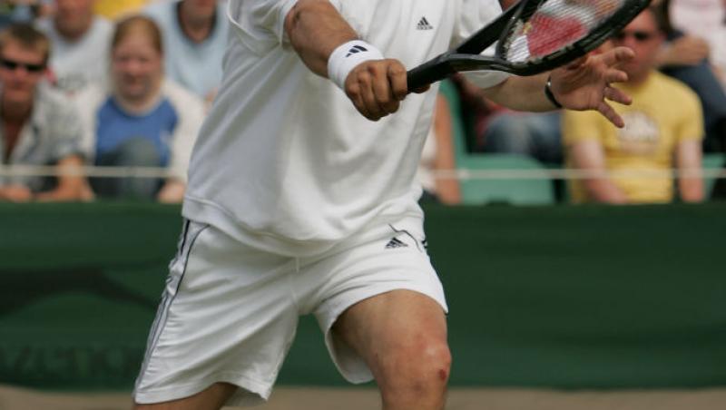 Ilie Năstase, jucând tenis, îmbrăcat în alb
