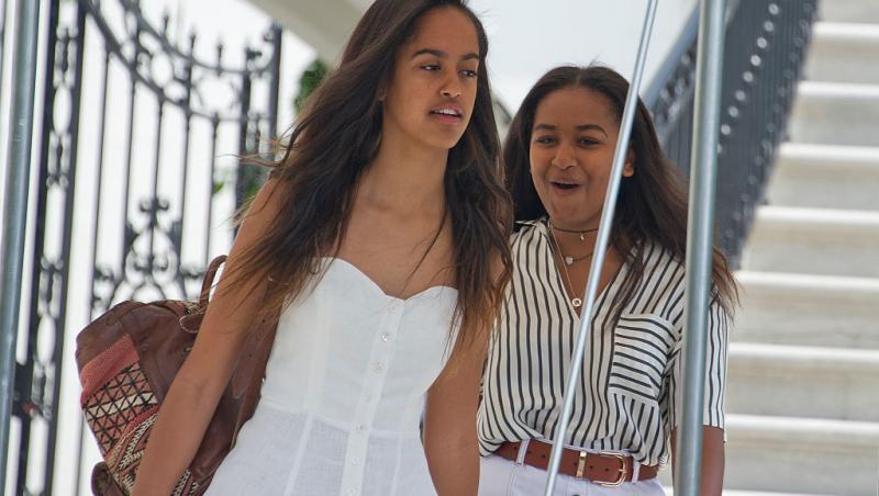 Sasha Obama și sora ei, Malia. Una dintre ele este îmbrăcată în rochie albă, cealaltă, în cămașă