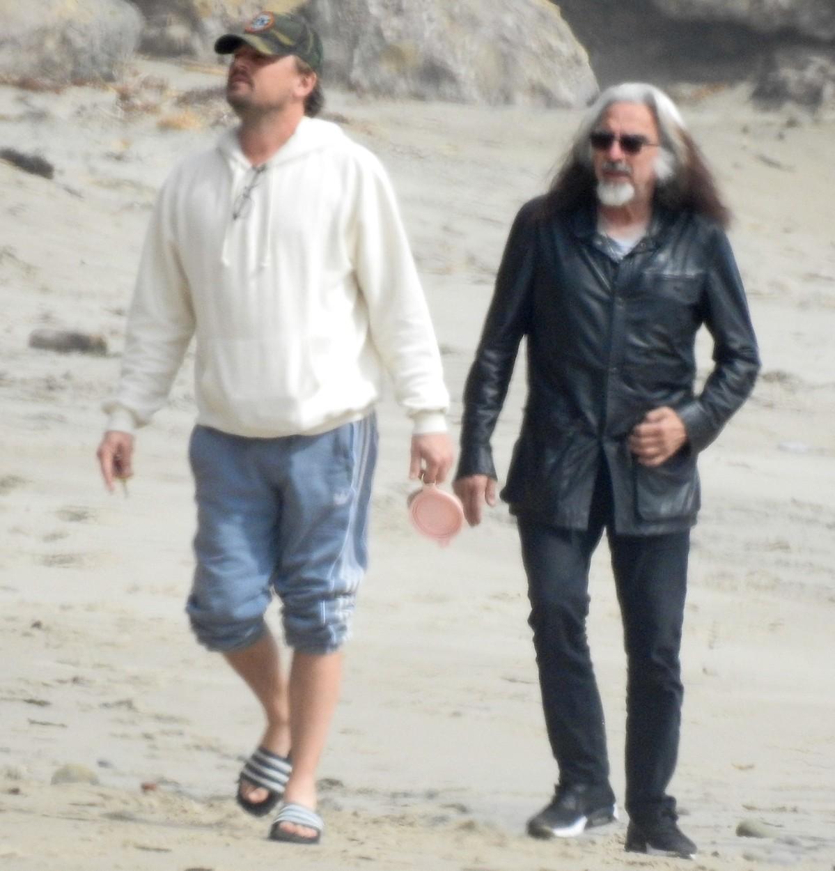 Leonardo DiCaprio, îmbrăcat într-un hanorac alb, alături de tatăl lui, pe plajă
