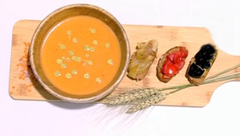 Supă cremă de linte cu sos de mentă și bruschete cu legume, prezentate pe un tocător de lemn