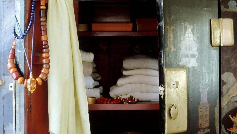 imagine cu un dulap vechi, in care sunt asezate haine