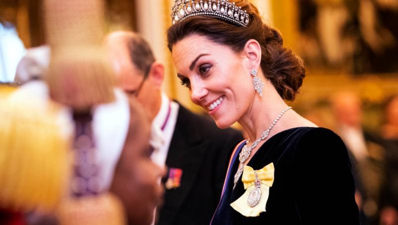 Kate Middleton, îmbrăcată într-o rochie neagră, în cadrul unui eveniment oficial la Palatul Buckingham, în 2019, purtând, de asemenea, Ordinul Familiei Regale, primit de la Regină