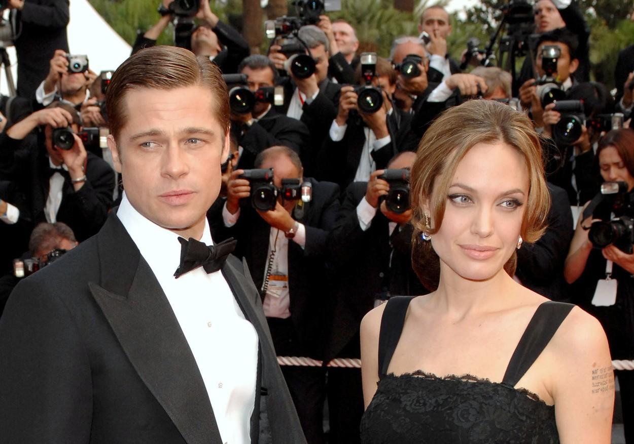 Angelina Jolie, cu părul prins, îmbrăcată într-o rochie neagră, și Brad Pitt, la costum negru cu papion