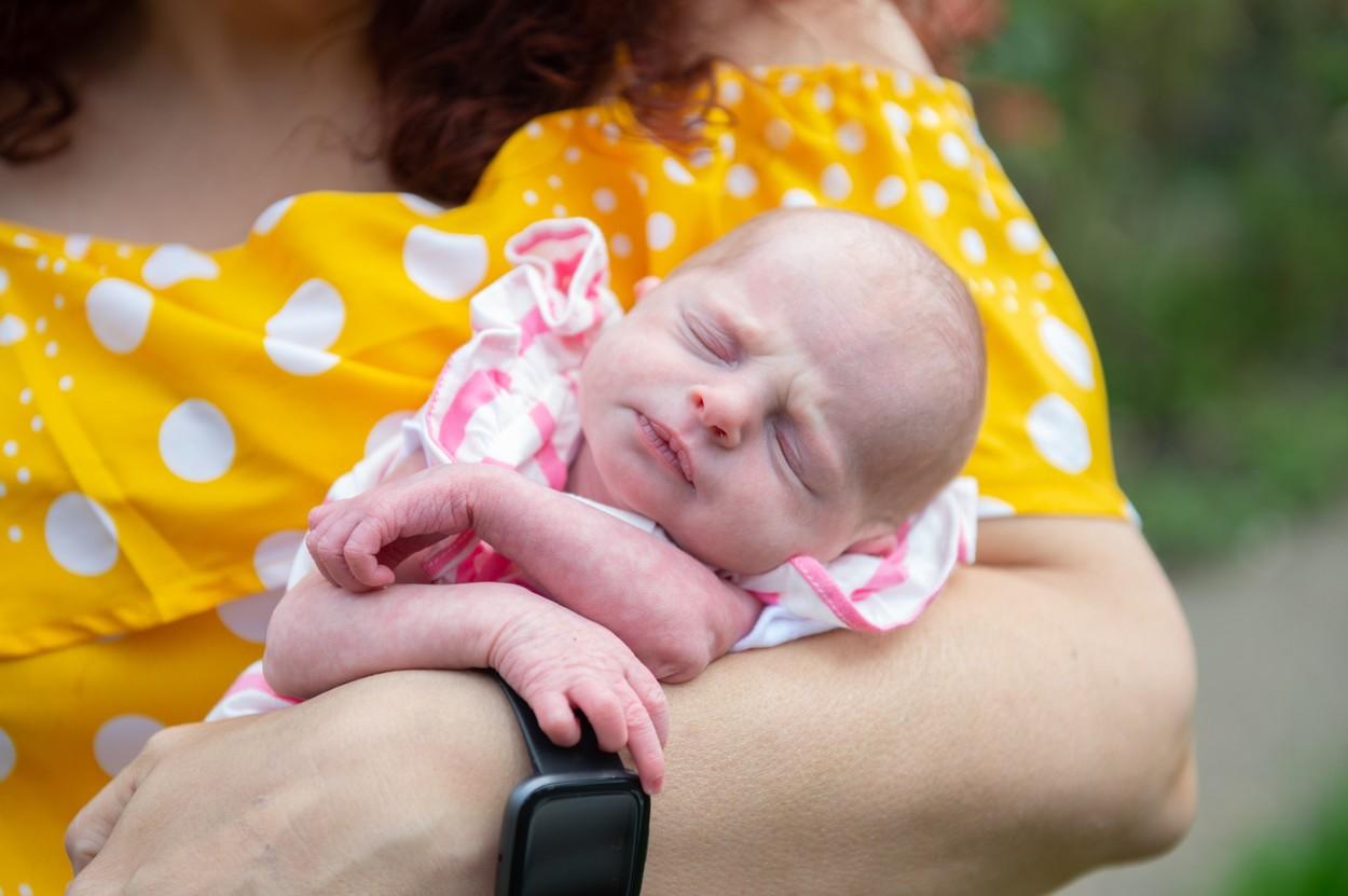 janice kerwick cu o bluza galbena, tinandu-si in brate fetita