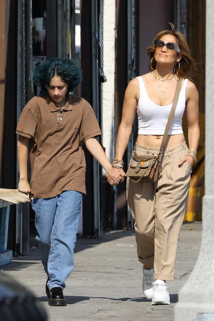 jennifer lopez si fiica ei emme pe strada, tinandu-se de mana, jlo poarta un top alb, geanta bej, pantaloni bej, tenesi albi, iar emme blugi albastri, parul albastru si un tricou maro