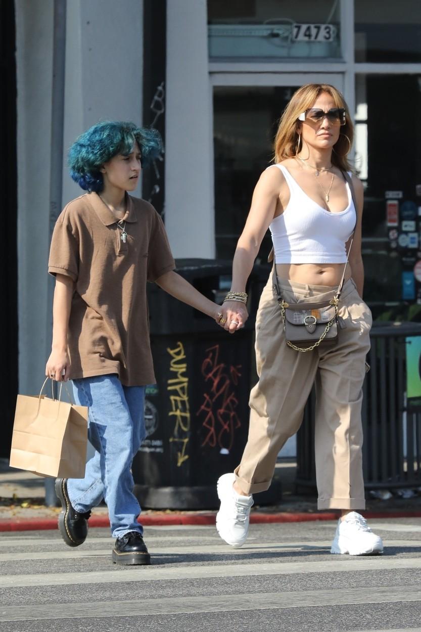 jennifer lopez si fiica ei emme pe strada, tinandu-se de mana, jlo poarta un top alb, geanta bej, pantaloni bej, tenesi albi, iar emme blugi albastri, parul albastru si un tricou maro