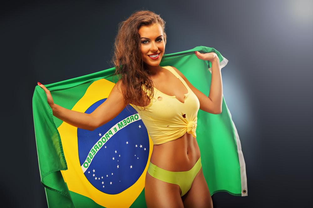 fata satena in costum de baie galben tinand in spate steagul braziliei