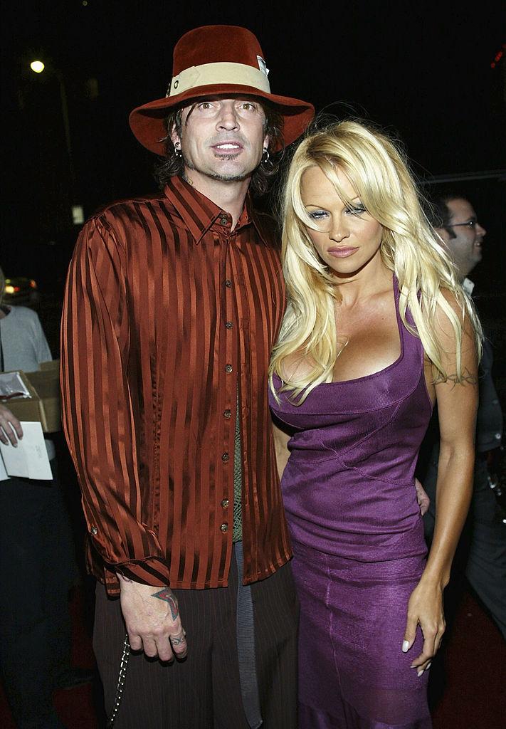 Pamela Anderson și rockerul Tommy Lee. Ea, cu decolteu, rochie mov, el, cu pălărie asortată cu bluza