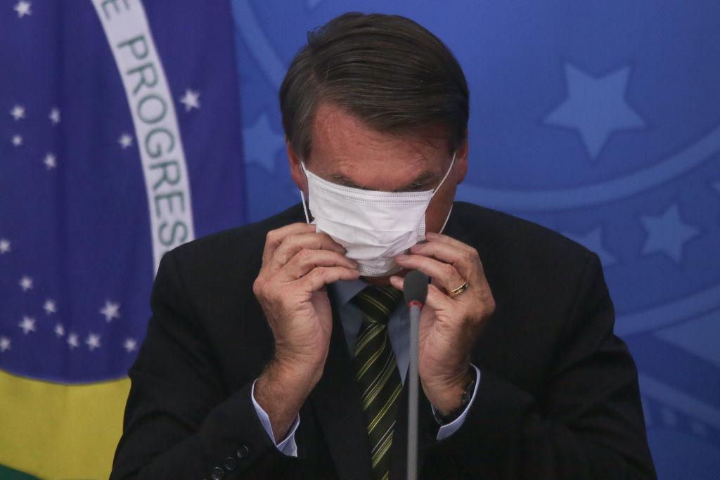 Jair Bolsonaro, președintele Braziliei, dându-și masca jos
