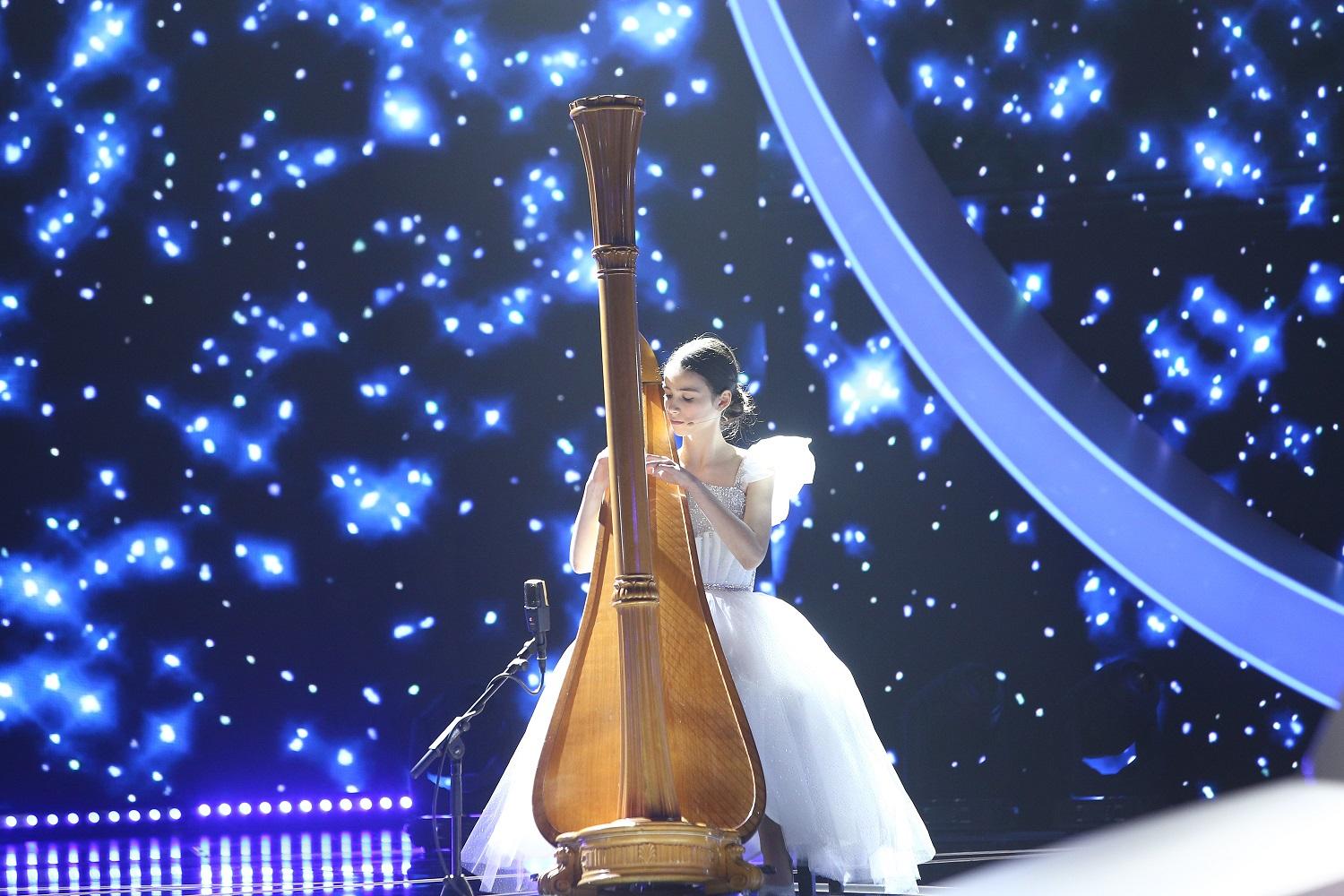maria ene pe scena la next star intr-o rochie alba cantand la harpa