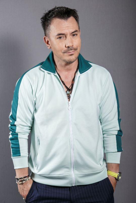 Răzvan Fodor, îmbrăcat într-o bluză sport, alb cu verde, cu mâinile în buzunare