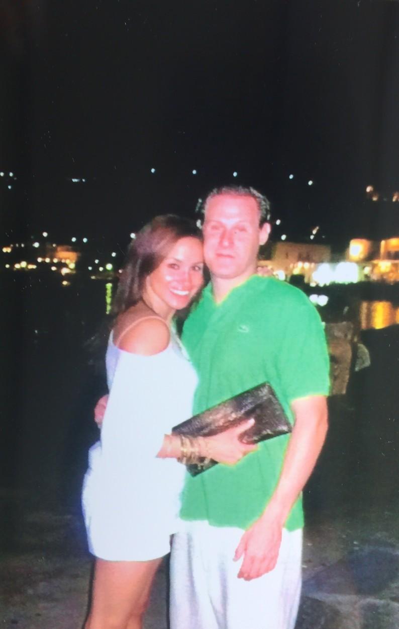 Trevor Engelson împreună cu fosta lui soție, Meghan Markle. Meghan Markle este îmbrăcată în alb, iar Trevor, în pantaloni deschiși și în tricou verde
