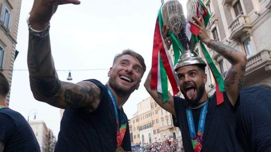 Ciro Immobile și Lorenzo Insigne în timp ce celebrau câștigarea trofeului Italiei la EURO 2020, unul tine trofeul in mana, altul face poza