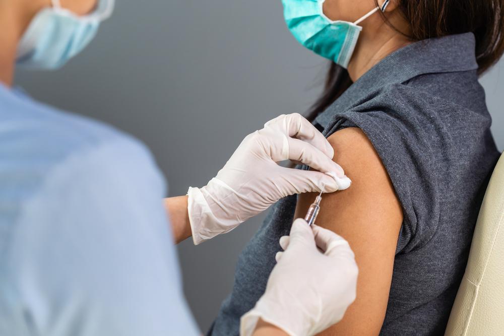 femeie la vaccin si asistenta care o vaccineaza