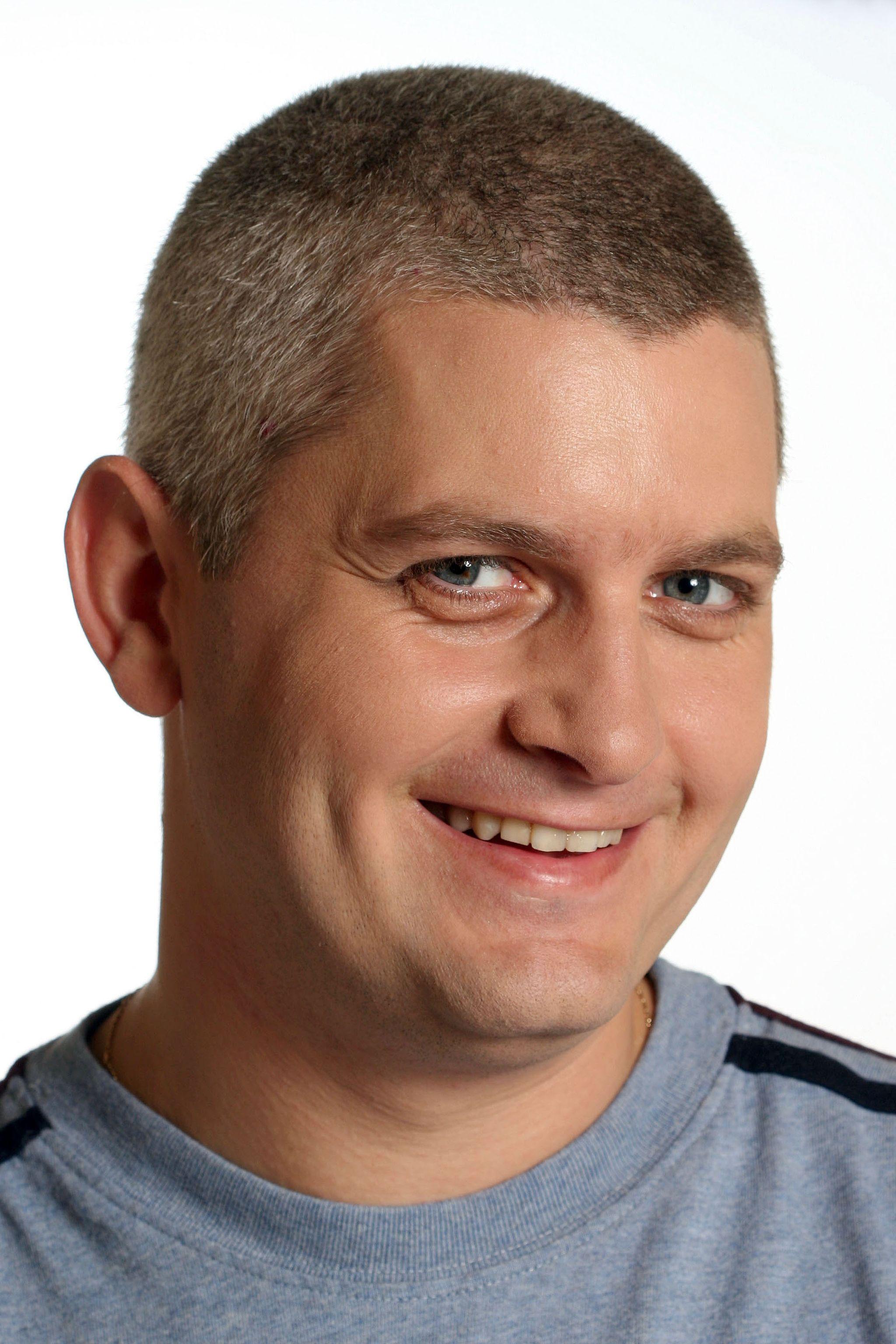 Virgil Ianțu, într-o bluză gri și zâmbește