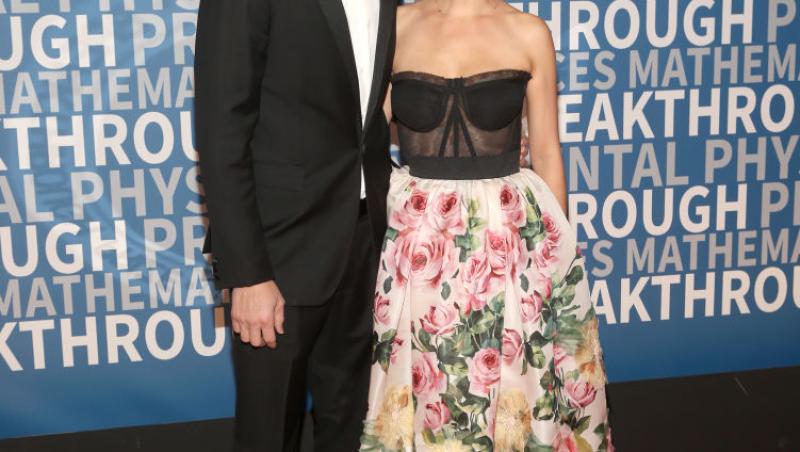 Mila Kunis și Ashton Kutcher, îmbrăcați elegant. El, în costum, ea, într-o rochie cu imprimeu