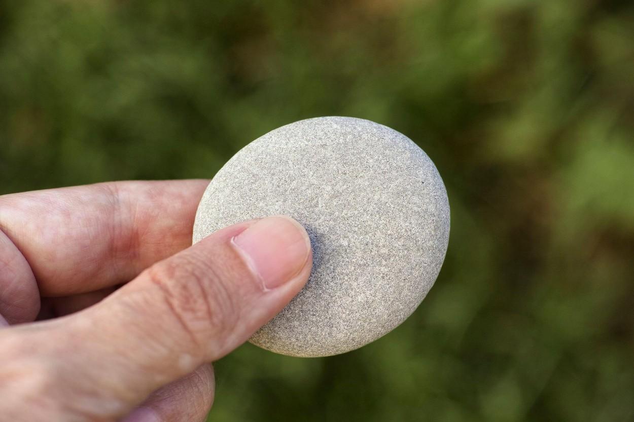 imagine cu o piatra tinuta in mana