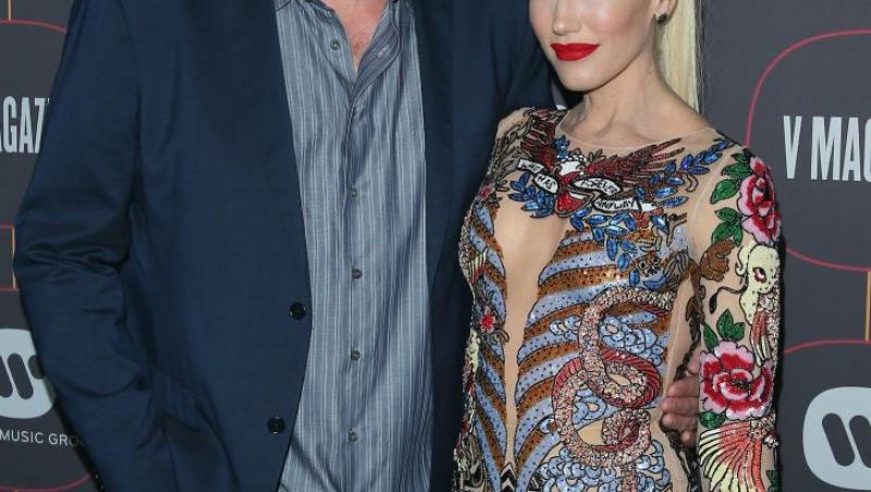 Gwen Stefani si sotul ei, Blake Shelton, la un eveniment public. El, în sacou și cămașă, ea, într-o rochie colorată, cu buze roșii