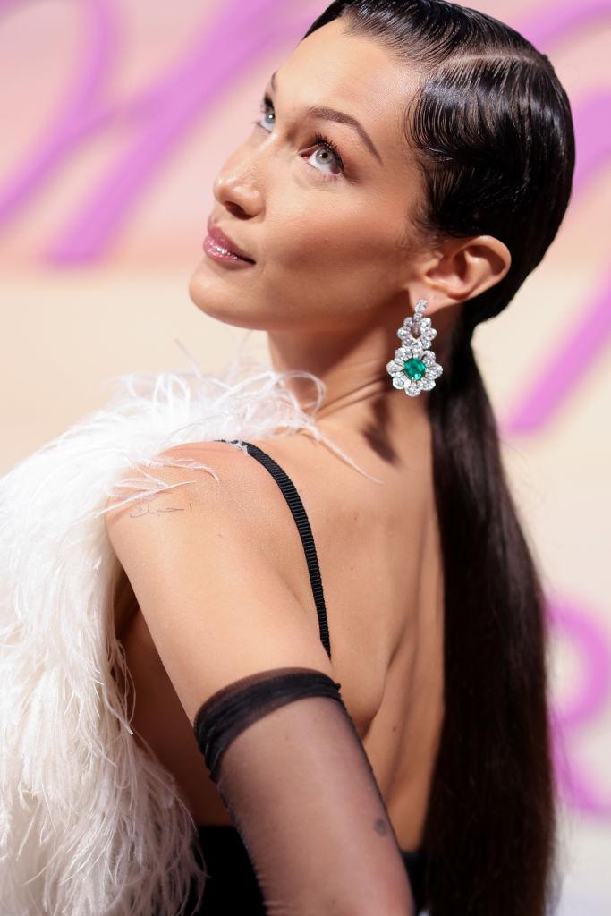 Bella Hadid, la petrecerea Chopard - Festivalul Internațional de Film de la Cannes, 2021, în rochie neagră, scurtă, cu puf alb