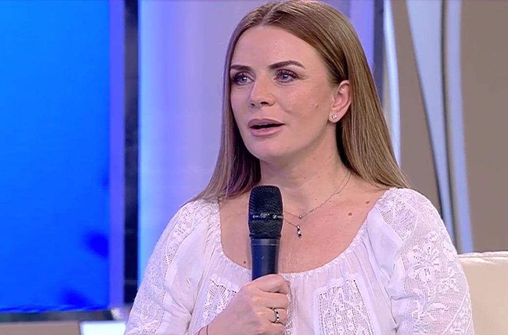 Marcela Fota într-o bluzp albă, vorbește la microfon