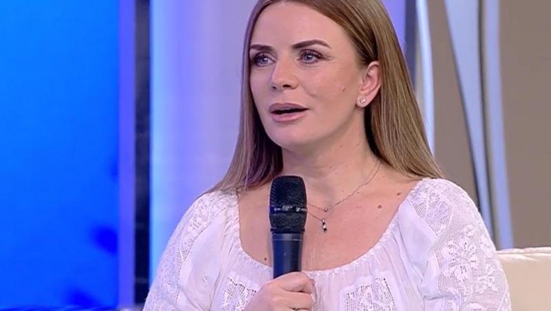 Marcela Fota într-o bluzp albă, vorbește la microfon