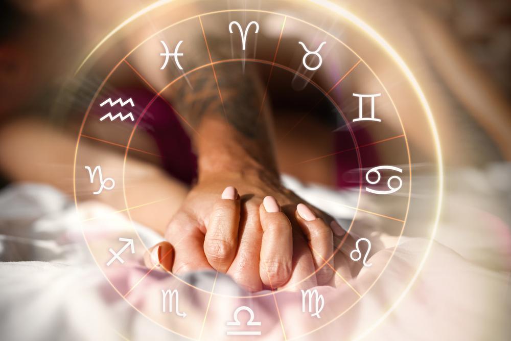 imagine cu mainile unui cuplu, in interiorul unui cerc cu cele 12 semne ale zodiilor din horoscop