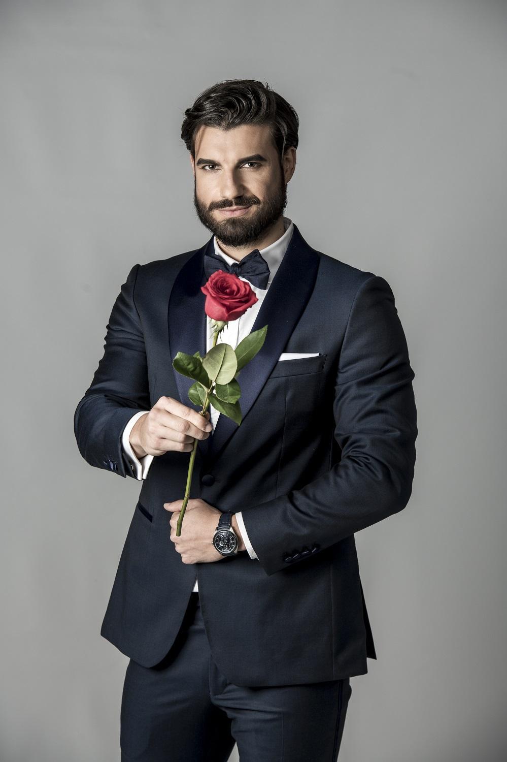 Andi Constantin în costum negru cu trandafir în mână
