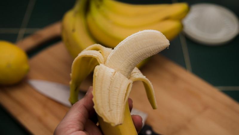 imagine cu mana unei femei tinand o banana