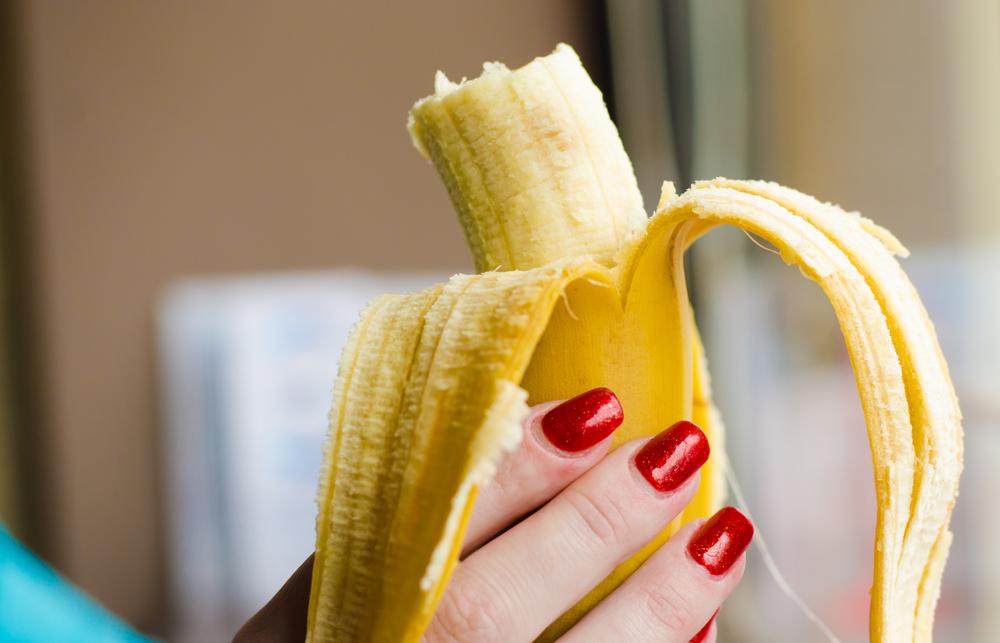 imagine cu o banana tinuta in mana unei femei